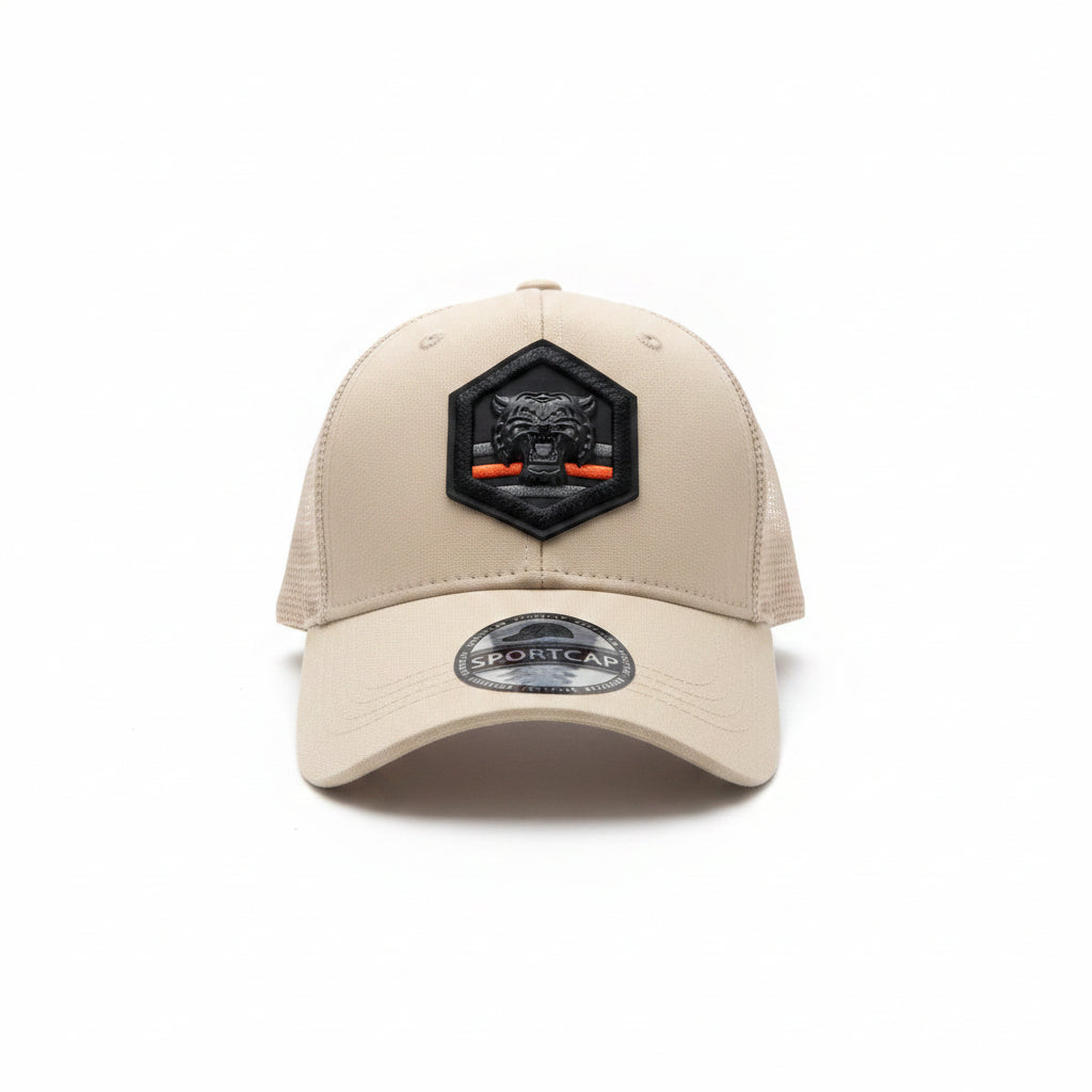 Front view of a beige unisex trucker cap featuring a hexagonal black tiger patch and mesh back