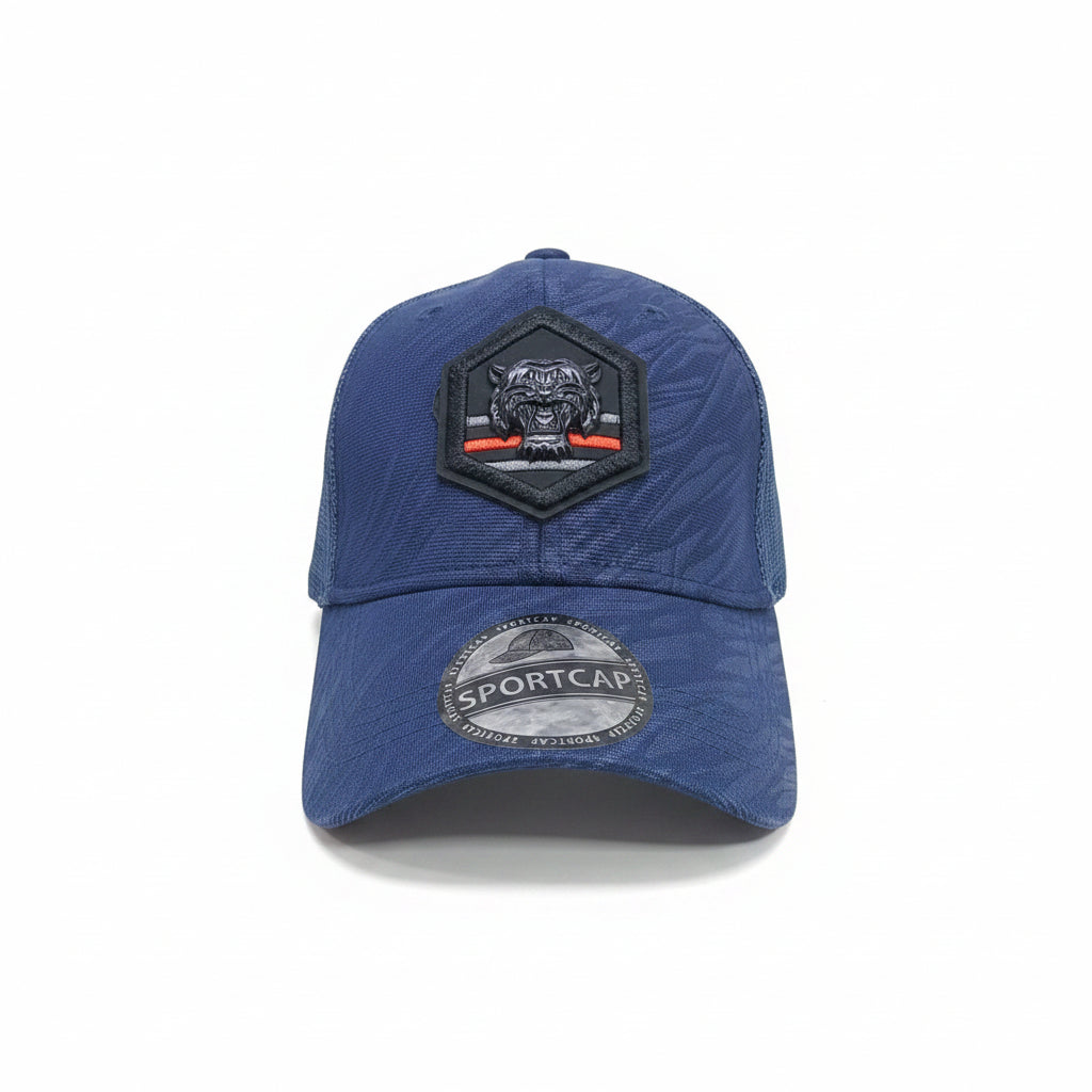 Front view of a blue unisex trucker cap featuring a hexagonal black tiger patch and mesh back
