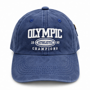Front view of a vintage blue washed baseball cap with white embroidered Olympic Athletic graphic.