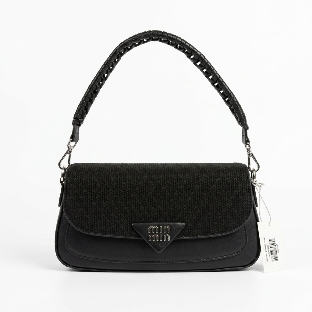 A black textured shoulder bag with a black woven strap, featuring a triangular metal logo plaque on the front flap and a white product tag attached, set against a plain white background.