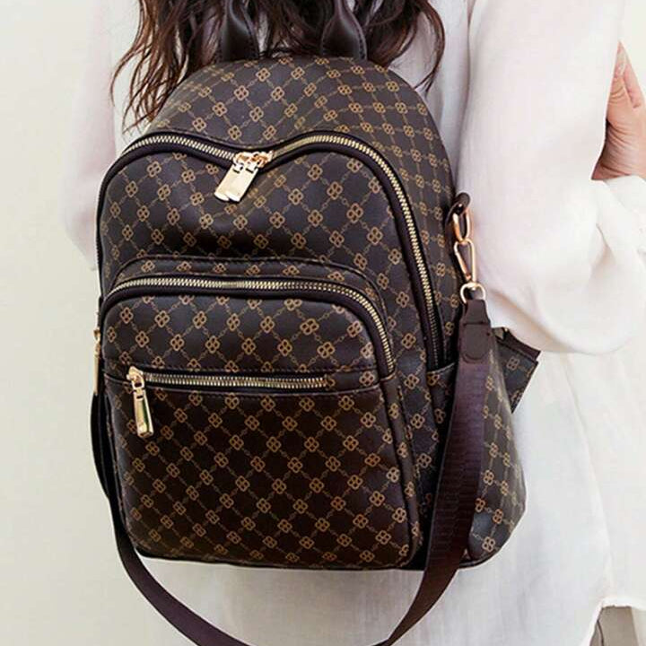 Person wearing a patterned backpack on a plain background