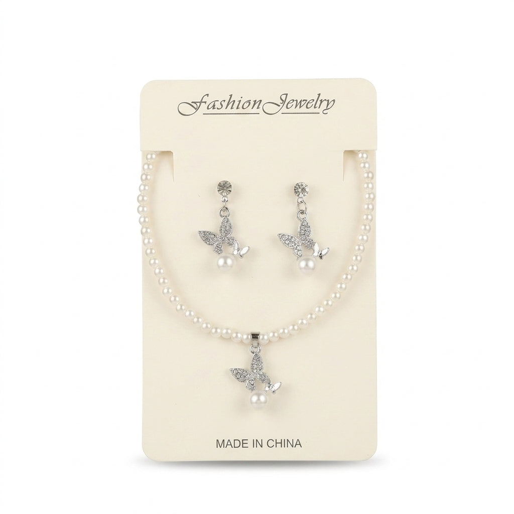Women's faux pearl strand necklace and matching drop earrings featuring rhinestone butterfly pendants displayed on packaging.