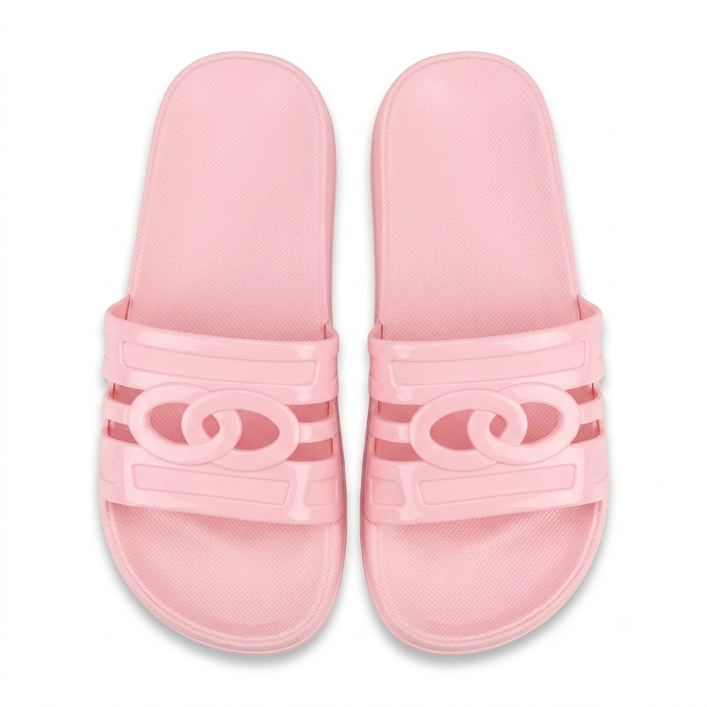 A pair of light pink slide sandals with a double interlocking circle design on the straps, shown from a top-down view on a white background.
