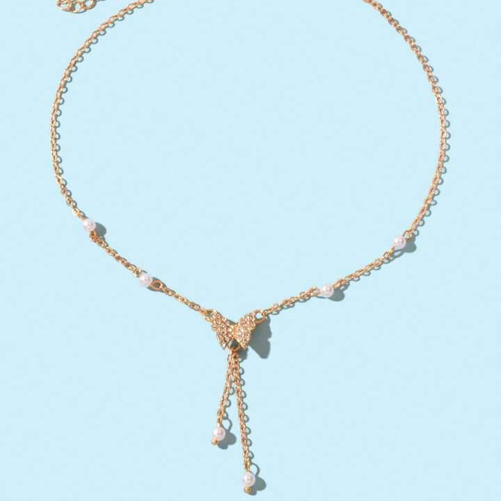 Gold necklace with heart pendants on a light blue background