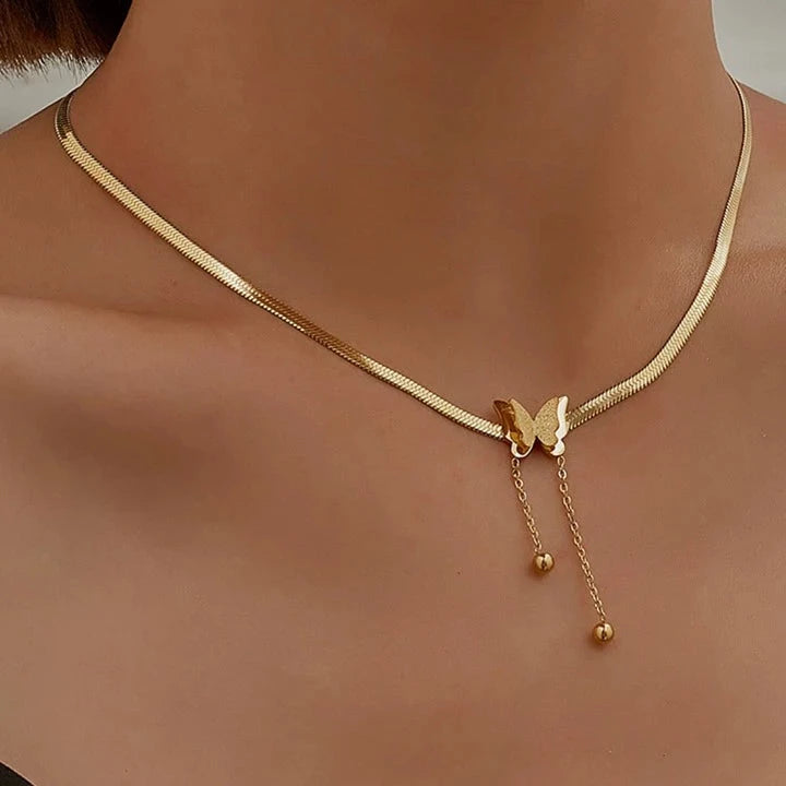 Gold necklace with a butterfly pendant on a mannequin