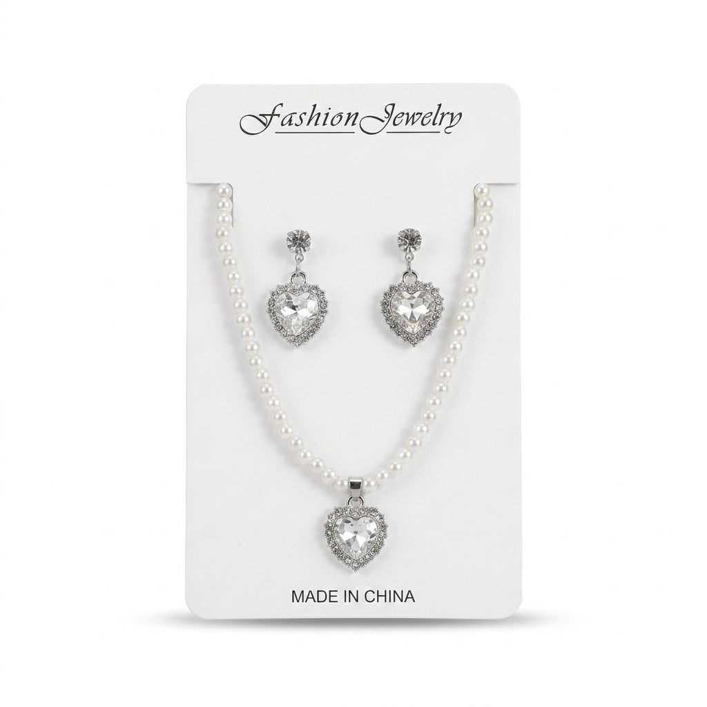 Women's faux pearl strand necklace and heart-shaped crystal drop earrings set on display card