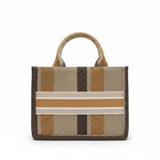 Striped handbag with a pattern of brown, beige, and white on a pink surface.